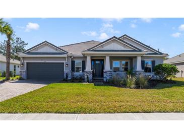 Charming single-story home featuring a well-manicured lawn, two-car garage, and inviting front porch at 1324 Arklow Cir, Ormond Beach, FL 32174