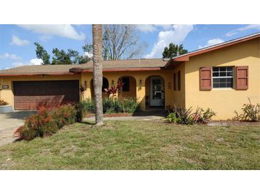 Charming single-story home featuring an arched entryway, colorful landscaping, and a one-car garage at 210 Dartmouth St, Deltona, FL 32725