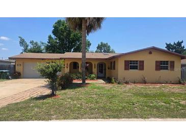 Charming single-story home with a well-maintained lawn and mature landscaping, complemented by a beautiful palm tree at 210 Dartmouth St, Deltona, FL 32725