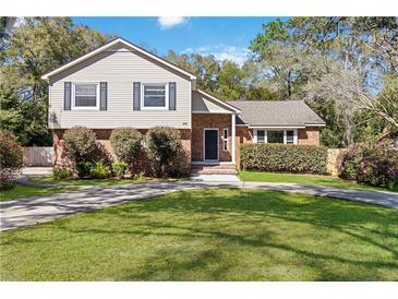 Charming two-story home featuring a brick and siding facade, lush landscaping, and a well-maintained front lawn at 259 Westchester Dr, Deland, FL 32724