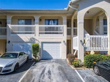 Charming condo featuring a white picket fence balcony, garages, and manicured landscaping at 3206 Sabal Palms Ct # A, Kissimmee, FL 34747