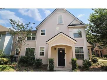 Charming two-story townhome showcasing a black front door and manicured landscaping at 3364 Westchester Square Blvd # 104, Orlando, FL 32835