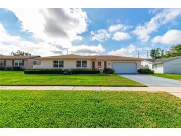 Charming single-story home with a manicured lawn, tidy landscaping, and a convenient two-car garage at 4416 Flagg St, Orlando, FL 32812