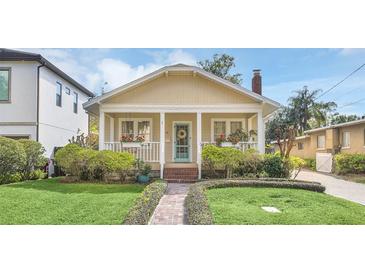 Charming home featuring a brick walkway, lush landscaping, and a welcoming front porch with flower boxes at 616 Sheridan Blvd, Orlando, FL 32804