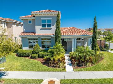 Charming two-story home featuring a tile roof, manicured landscaping, and a welcoming entrance at 9406 Mere Pkwy, Orlando, FL 32832