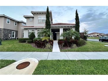 Charming two-story home featuring a beautiful front yard, manicured landscaping, and a tile roof at 9406 Mere Pkwy, Orlando, FL 32832