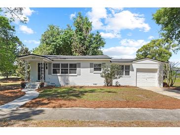 Charming single-story home with a white exterior, gray shutters, and a well-maintained front yard at 1037 N Virginia Ave, Winter Park, FL 32789