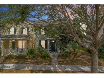 Charming townhome featuring lush landscaping, covered entry, and sidewalk at 14143 Ancilla Blvd, Windermere, FL 34786