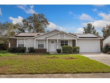 Charming single-story home featuring a well-maintained lawn, solar panels and an attached two car garage at 414 Tranquille Oaks Dr, Ocoee, FL 34761