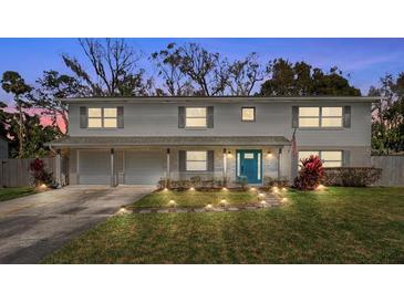 Charming two-story home boasts a well-manicured lawn, two car garage, and a bright blue front door at 533 Little Wekiva Rd, Altamonte Springs, FL 32714