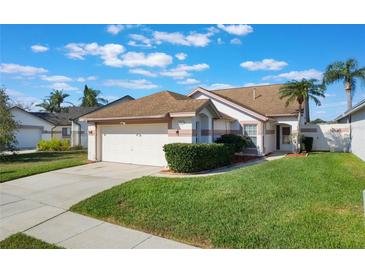 Charming single-story home with a well-maintained lawn and a two-car garage at 5795 Parkview Lake Dr, Orlando, FL 32821