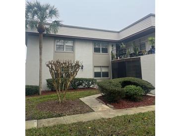 Charming condo featuring well-maintained landscaping with mature palm trees and decorative bushes at 96 Windtree Ln # 203, Winter Garden, FL 34787