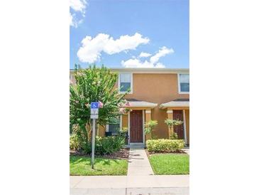 Charming townhome featuring a well-manicured lawn and a covered front entry at 1132 Chelsea Dr, Davenport, FL 33897