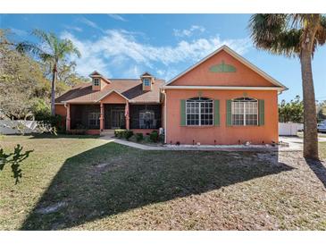 Charming home with a screened porch and lush landscaping at 1031 Kings Hwy, Kissimmee, FL 34744