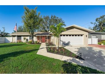 Charming single-story home featuring a manicured lawn, brick accents, and a two-car garage at 1232 Corbett Ln, Orlando, FL 32806