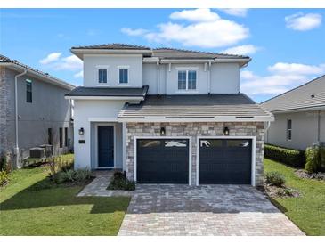 Beautiful two-story home featuring a stone facade, a two-car garage, and professionally landscaped front yard at 16112 Vetta Dr, Montverde, FL 34756