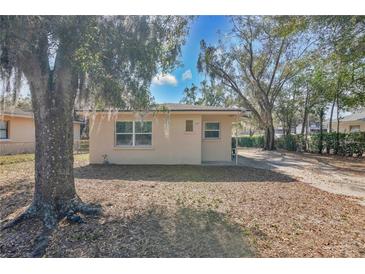 Quaint single-story home with mature trees creating a serene and inviting atmosphere at 203 North E Blvd, Davenport, FL 33837
