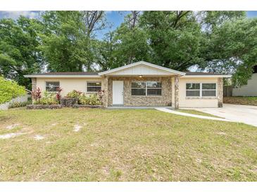 Charming single-story home with stone accents, a well-maintained lawn, and mature trees in a serene neighborhood at 3675 Rundo Dr, Orlando, FL 32818