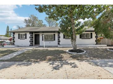 Charming single-story home with a beautifully landscaped front yard and mature tree at 4425 Signal Hill Rd, Orlando, FL 32808