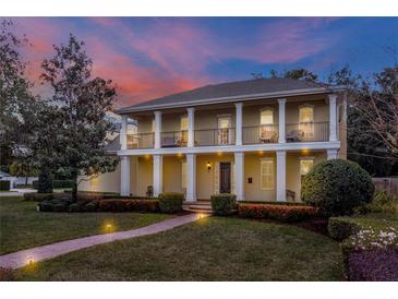 Stately two-story home featuring columns, a landscaped yard, and a brick walkway at 450 Lakewood Dr, Winter Park, FL 32789