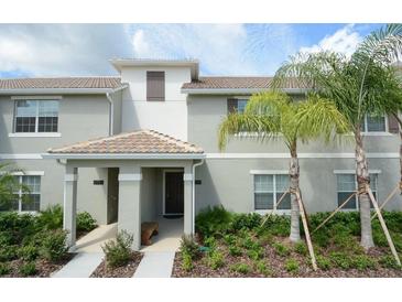 Inviting townhome exterior with well-maintained landscaping and covered front porch entry at 4879 Clock Tower Dr, Kissimmee, FL 34746