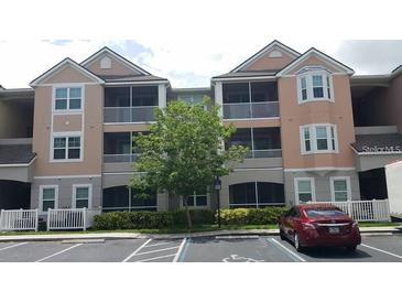 Exterior view of condo building featuring screened patios, and accessible parking in front at 6412 Queens Borough Ave # 109, Orlando, FL 32835