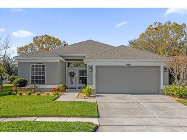 Charming single-story home with a well-manicured lawn and inviting curb appeal on a sunny day at 9816 Palmetto Dunes Ct, Orlando, FL 32832