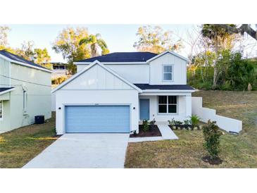 Charming two-story home boasts a well-manicured lawn and light blue garage door, enhancing its curb appeal at 1045 Morningside Dr, Eustis, FL 32726