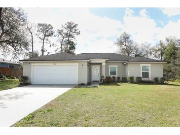 Attractive single-story home with a garage, a manicured lawn, and mature landscaping at 1090 Parnell Ct, Deltona, FL 32738