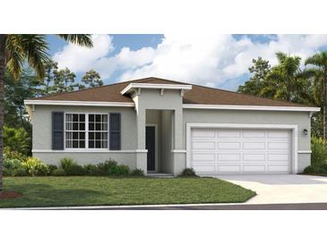 Charming single-story home with a two-car garage, gray exterior, and well-maintained lawn at 1128 Clay Blvd, Tavares, FL 32778