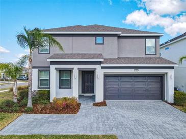 Beautiful two-story home featuring a gray stucco exterior, attached garage, and well-manicured landscaping at 178 Marcello Blvd, Kissimmee, FL 34746