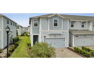 Charming two-story home with light blue siding, a one-car garage, and a well-manicured front yard at 2916 Satire St, Kissimmee, FL 34746