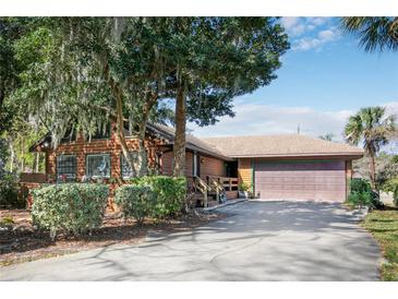 Charming single-Gathering home with a well-manicured yard, a covered porch, and an attached garage at 2929 Lakeshore Dr, Mount Dora, FL 32757