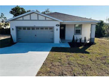 New construction home featuring an attached garage, new landscaping, and a concrete driveway at 327 15Th N St, Haines City, FL 33844