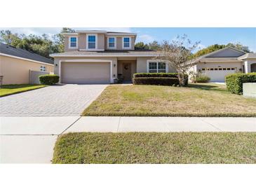 Charming two-story home with well-manicured lawn and a brick driveway at 34429 Alameda Dr, Sorrento, FL 32776
