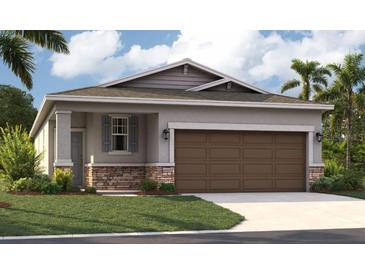 Charming one-story home featuring stone accents, a two-car garage, and a well-manicured lawn at 3495 Salvia Ct, Tavares, FL 32778