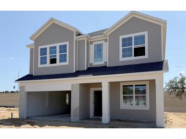 New two-story home features a gray exterior, welcoming front porch, and an attached two-car garage at 726 Pointe Emerson Blvd, Apopka, FL 32703