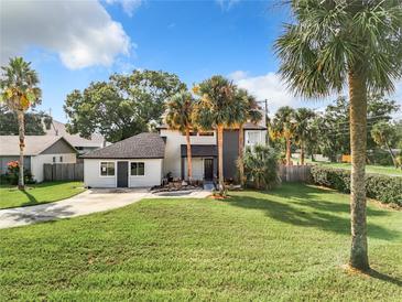 Landscaped front yard with mature palms, lush lawn, and charming curb appeal in a lovely residential neighborhood at 1040 Waverly Dr, Longwood, FL 32750