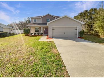 Charming two-story home with neutral paint, large garage, well-maintained lawn and mature trees at 11392 Sw 58Th Cir, Ocala, FL 34476