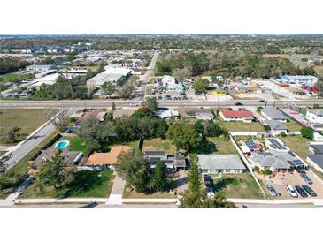 Neighborhood view of a single Gathering home with mature trees and a blue swimming pool at 1816 Jasper Drive, Orlando, FL 32807