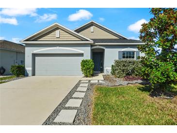 Charming single-Gathering home featuring a well-manicured front yard and neutral-toned exterior at 301 E Fiesta Key Loop, Deland, FL 32720