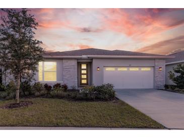 Charming single-story home with a well-manicured lawn, stone accents, and a two-car garage at 367 Sofia Ln, Lake Alfred, FL 33850