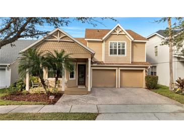 Charming two-story home featuring a covered porch, lush landscaping, and a two-car garage at 4019 Alcott Cir, Orlando, FL 32828