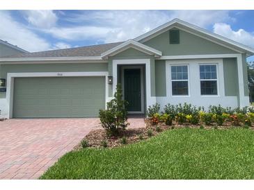 Inviting home featuring a brick driveway, manicured lawn, and tasteful landscaping at 5960 Vision Rd, St Cloud, FL 34771