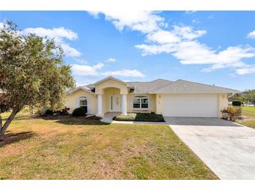 Charming single Gathering home featuring a two car garage and well-maintained lawn with mature tree at 700 Roby Ct, Dundee, FL 33838