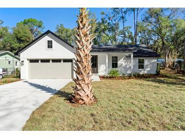 Charming renovated single-story home with a light gray garage door and manicured front lawn at 1175 20Th St, Orange City, FL 32763