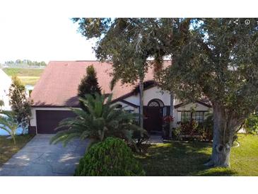 Charming single-story home featuring a well-maintained lawn, mature landscaping, and a two-car garage at 12017 Fambridge, Orlando, FL 32837