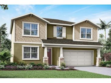 Two-story home featuring shake accents, columns, a two-car garage, and fresh landscaping at 13154 Pergola Ave, Orlando, FL 32832