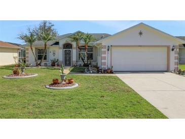 Well-maintained single Gathering home featuring green grass, a two car garage, and multiple palm trees at 1646 Arash Cir, Port Orange, FL 32128