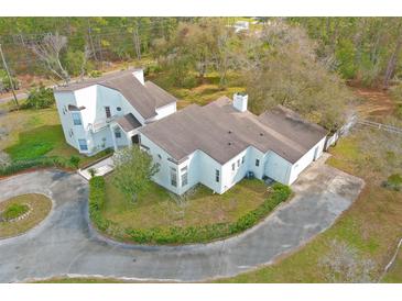 Expansive aerial view of a white two-story home with a large circular driveway and mature landscaping at 20000 Oberly Pkwy, Orlando, FL 32833